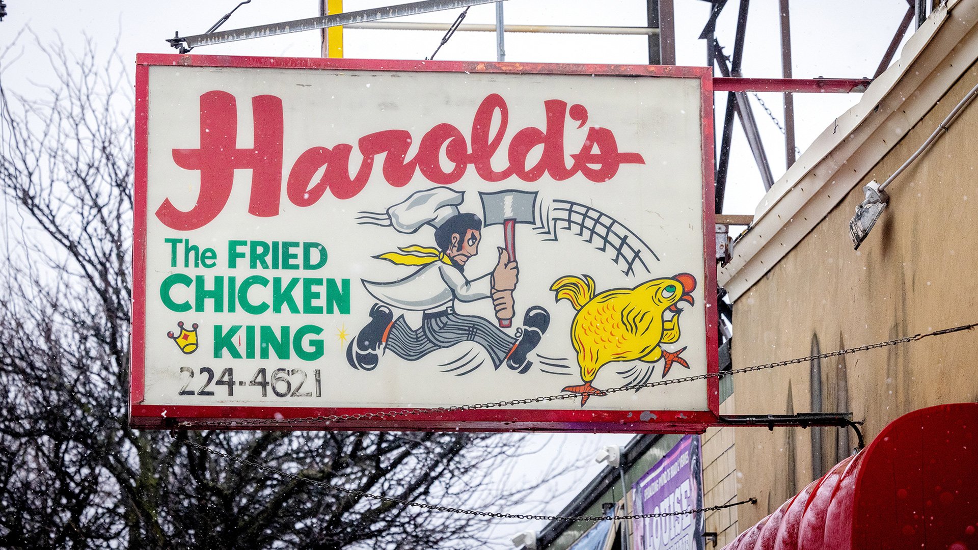 The signage above Harold's showing a man with an axe chasing a chicken