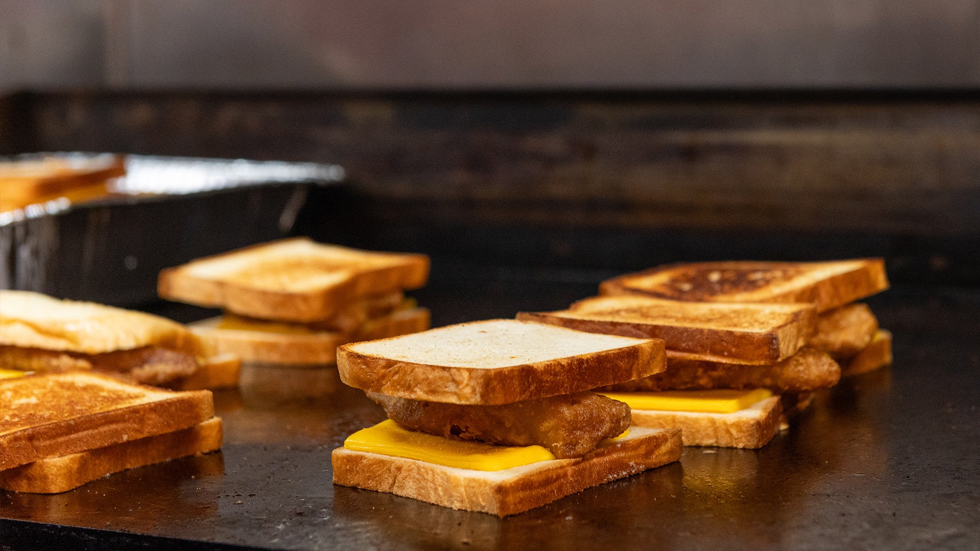 Close up of a fish sandwich on the griddle