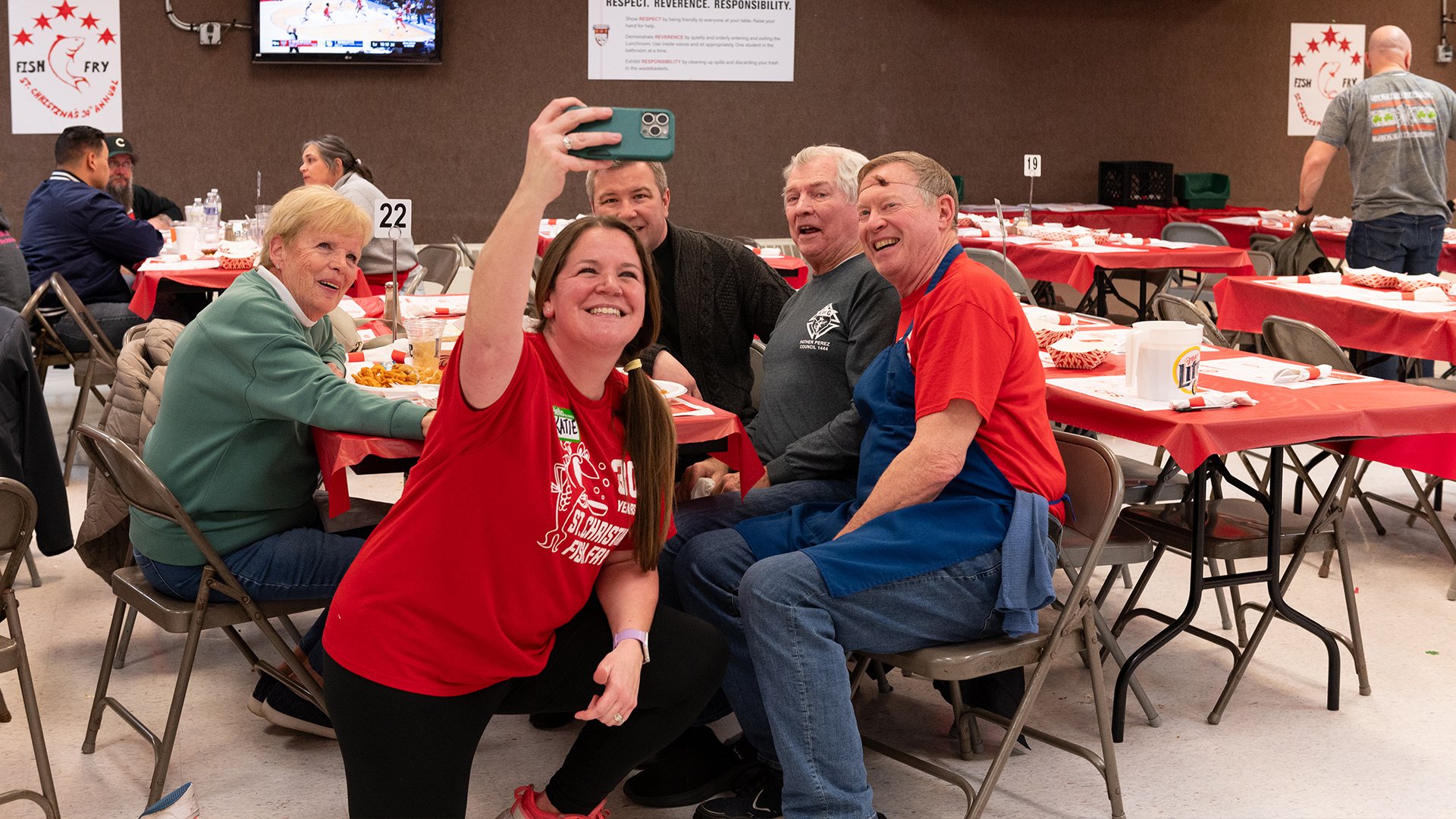 A volunteer taking pictures with guests at a table