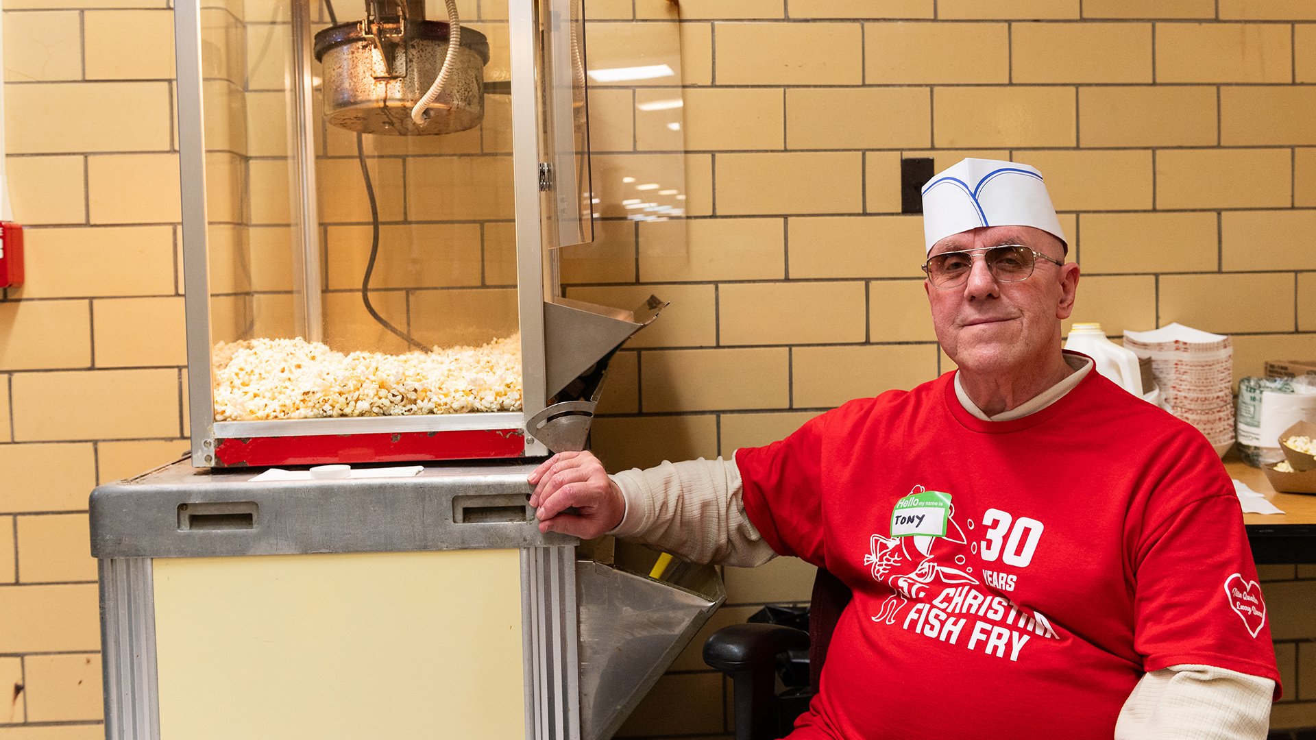 Tony Baran sitting in front of the popcorn machine