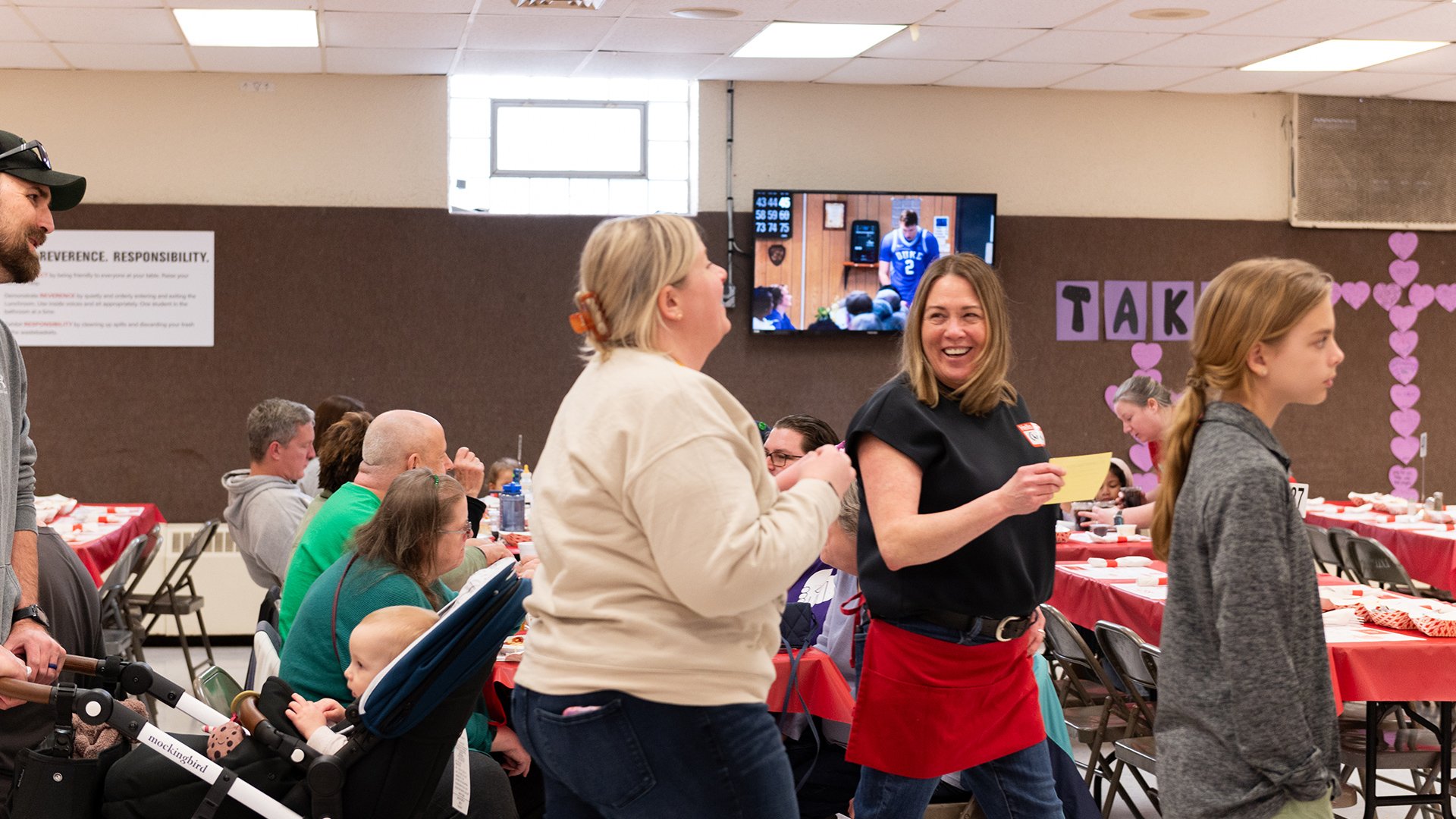 A line of guests smiling and laughing in the cafeteria