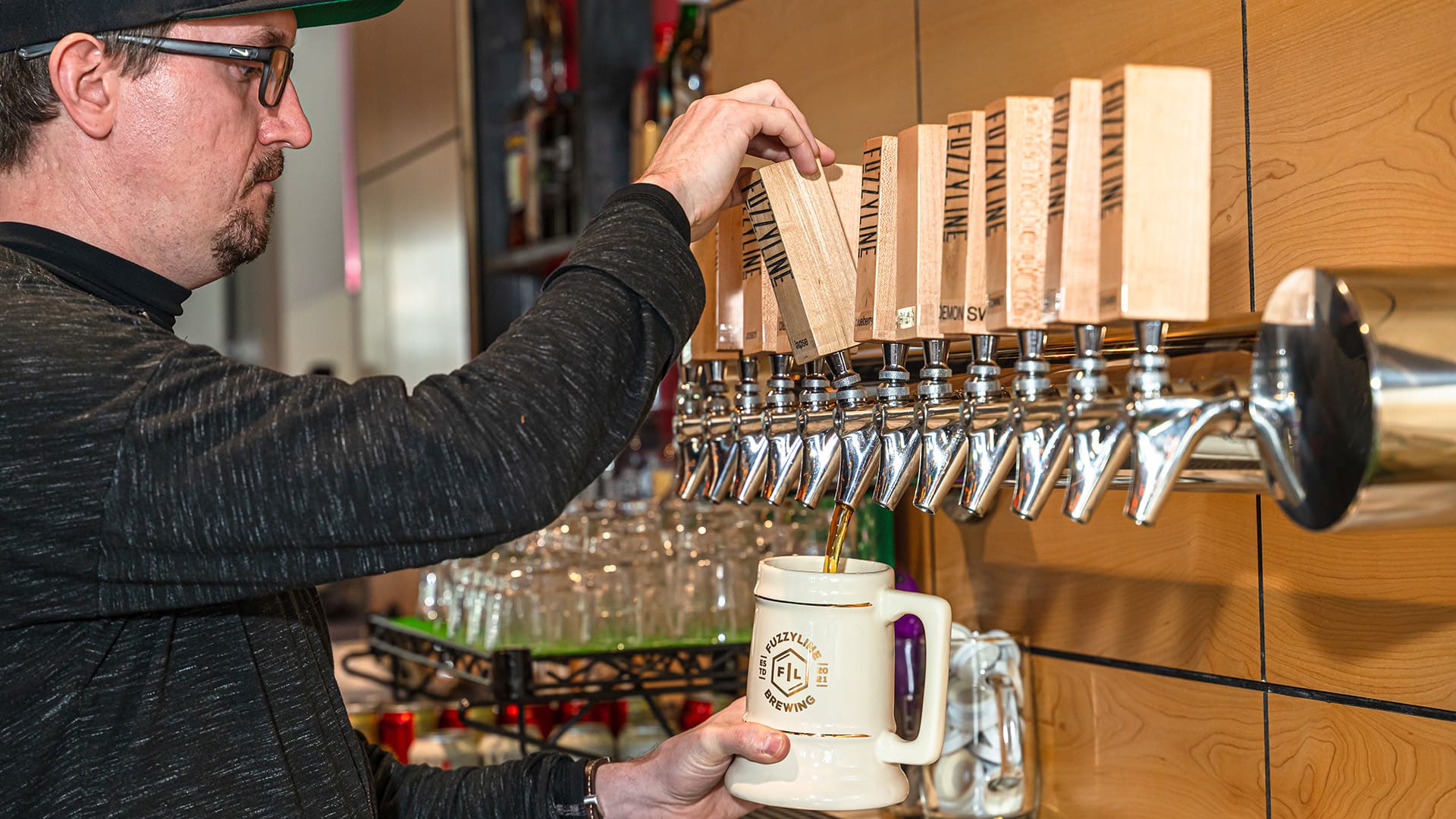 Alex pours beer from the tap into a stein