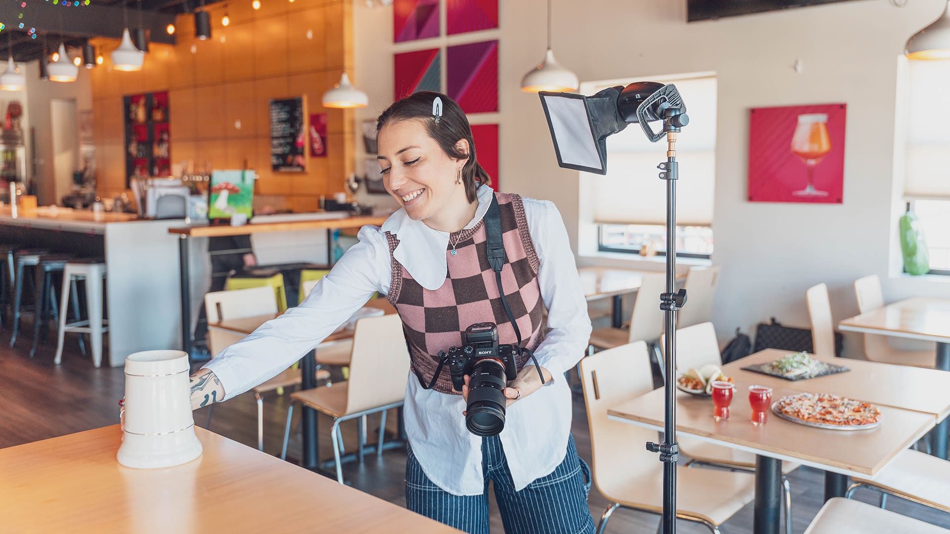 A photographer sets up a shot with a beer stein on a table.