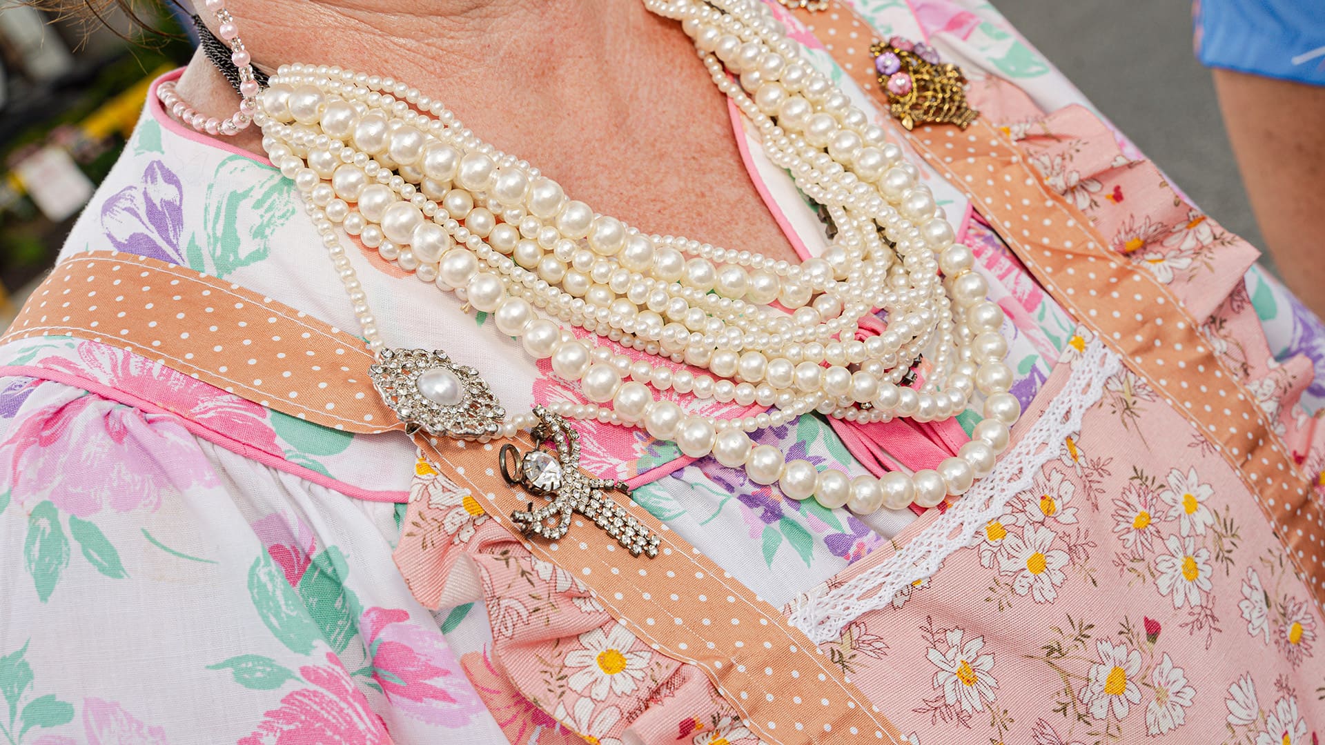 Closeup of multiple pearl necklesses and pendants on an apron