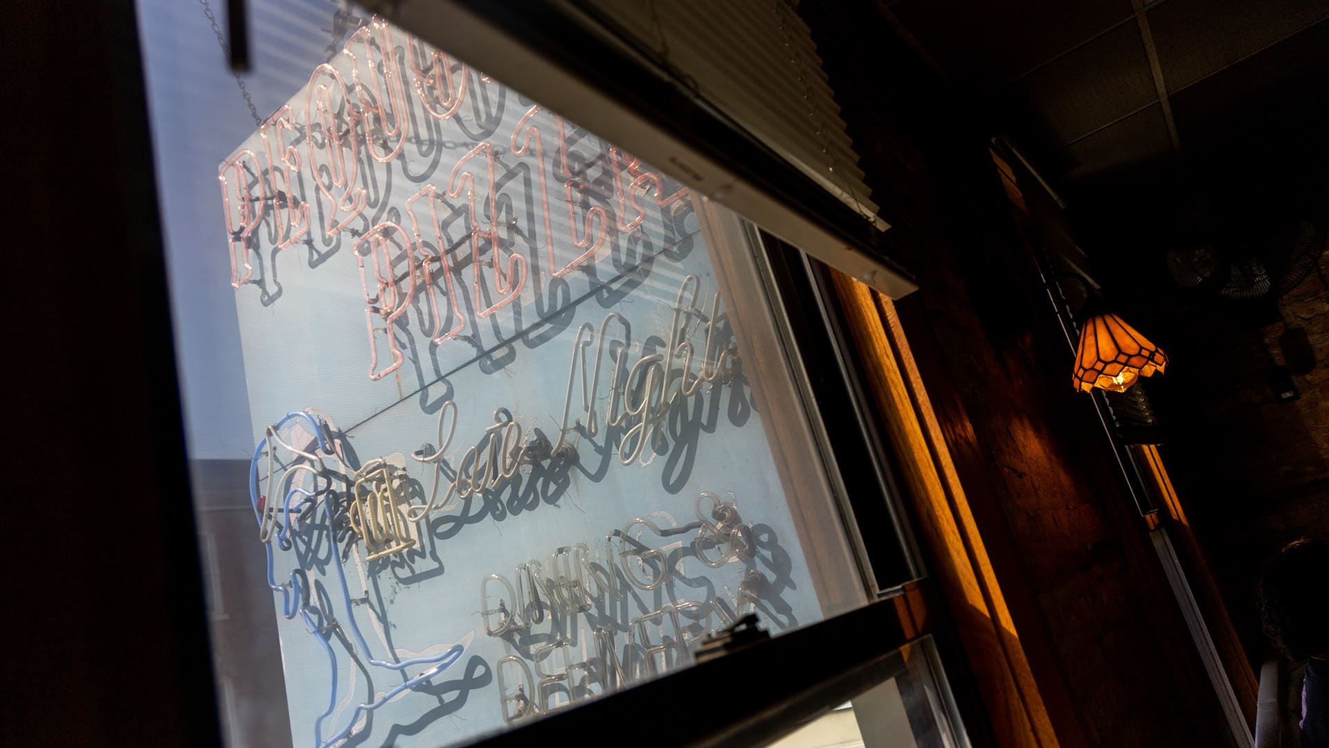 The Pequod's sign seen through a window of the restaurant
