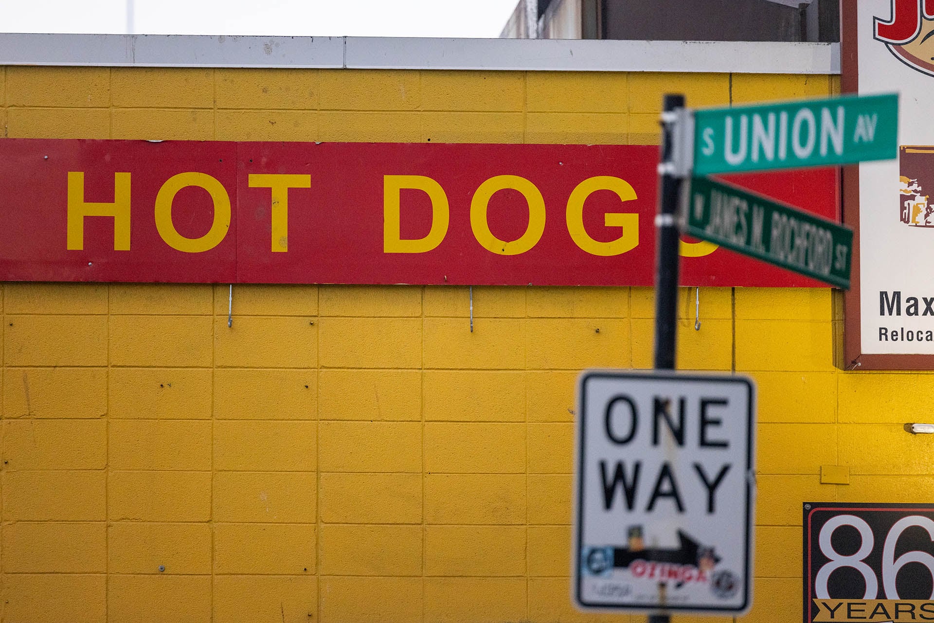 “Hot Dogs” sign on the yellow wall of Jim’s Original at the corner of Union Avenue