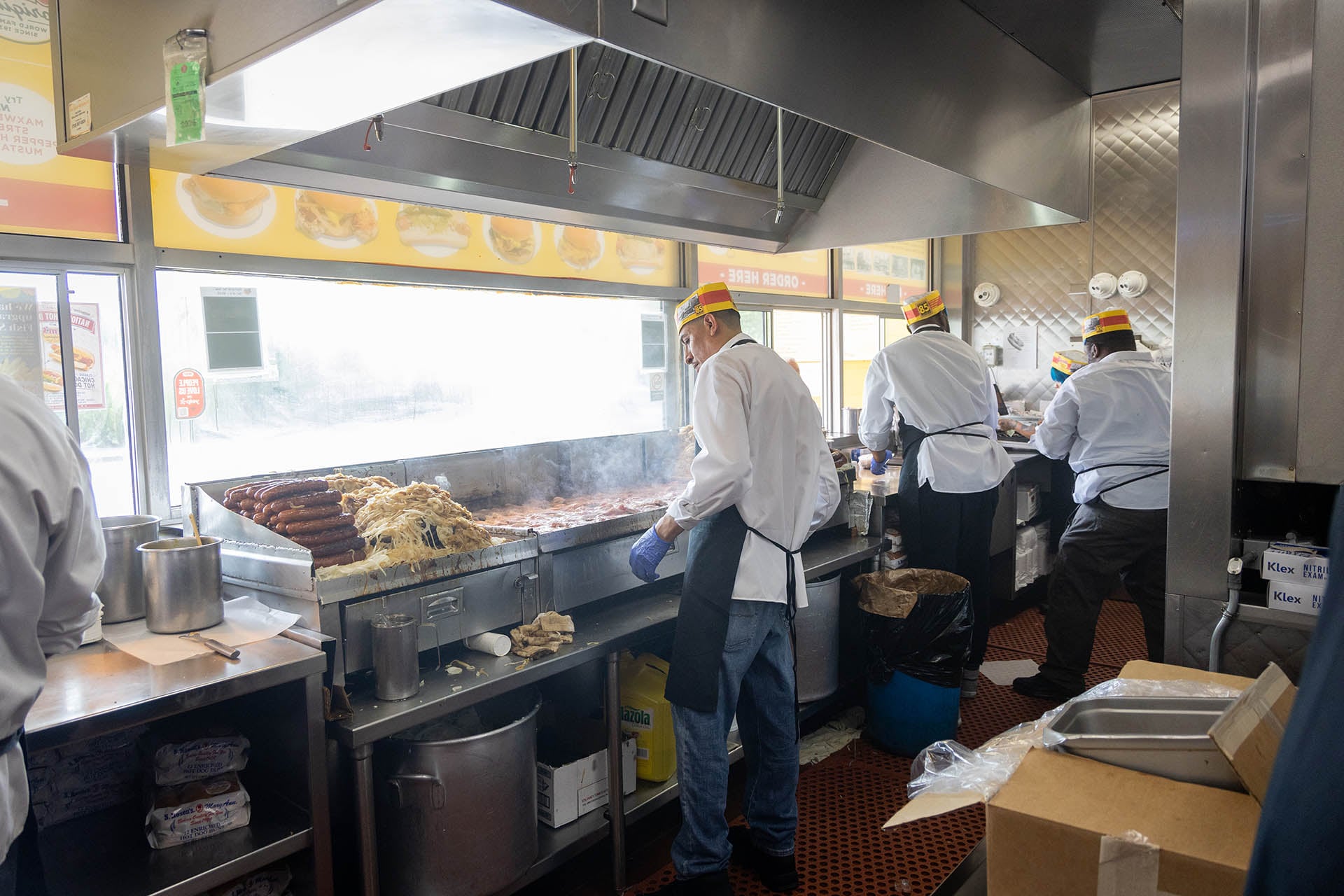 Workers at the grill inside the kitchen at Jim’s Original