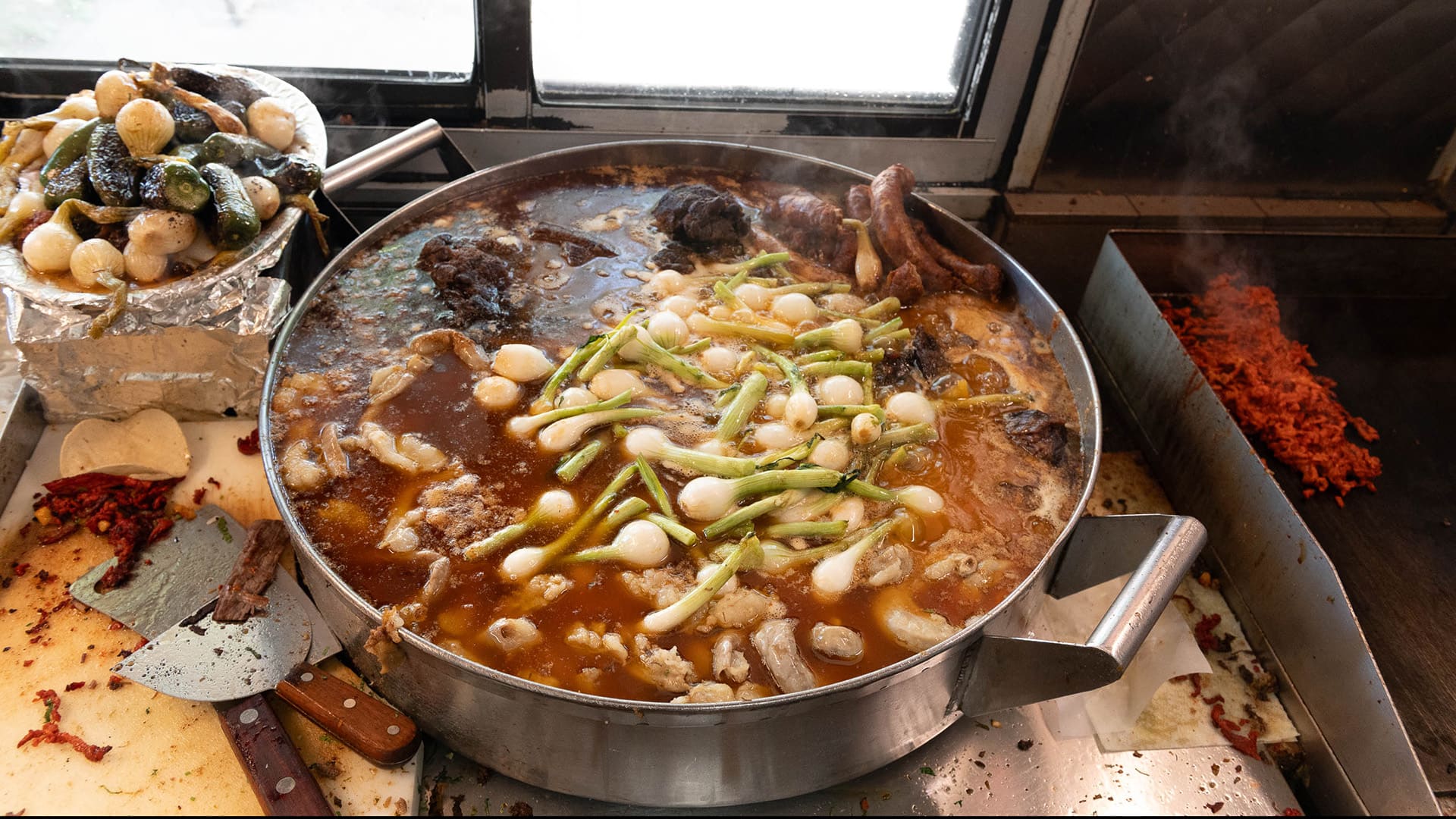 A pot of meat, broth, and onions bubbles