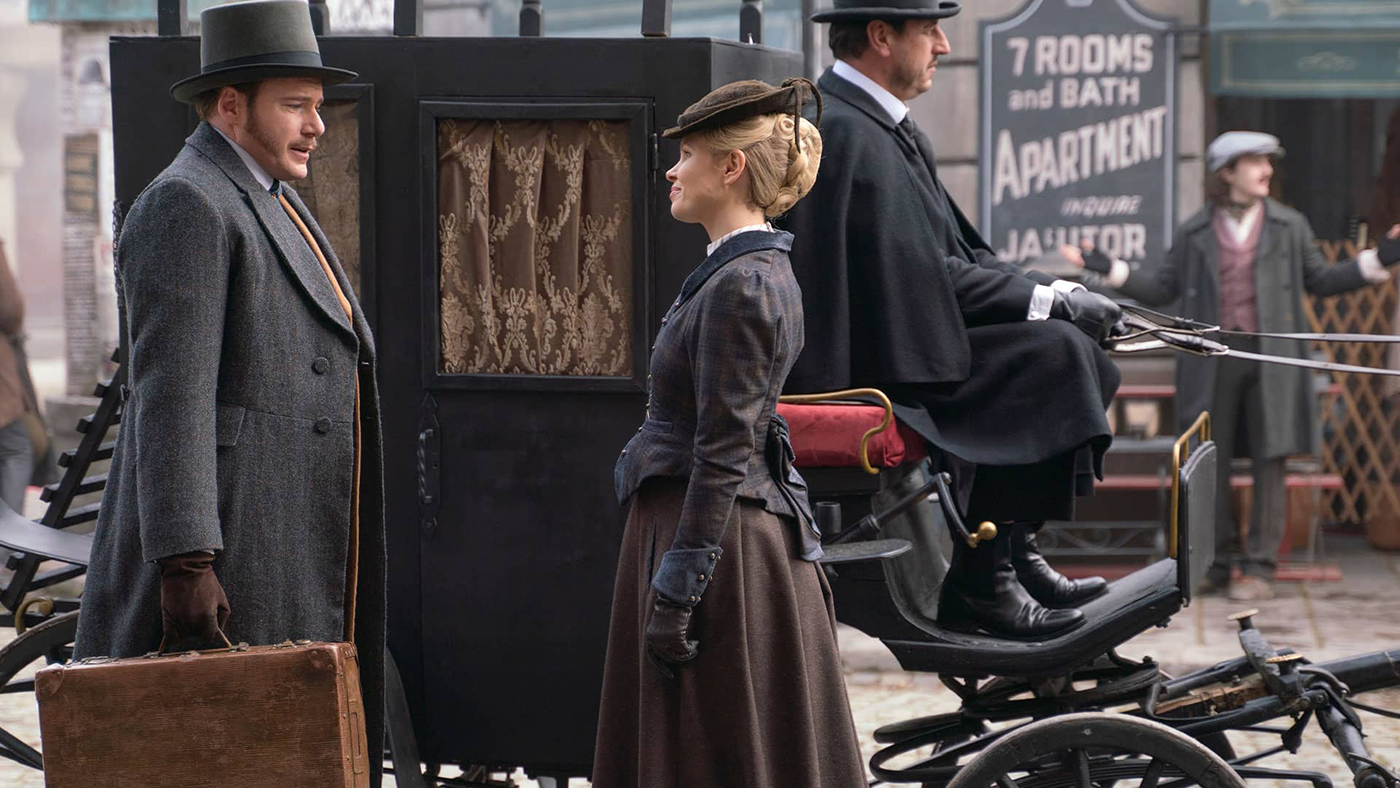 Eliza and Nash stand in front of a carriage
