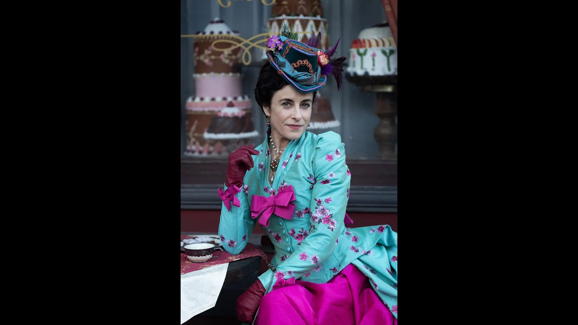 A woman in a colorful hat and dress