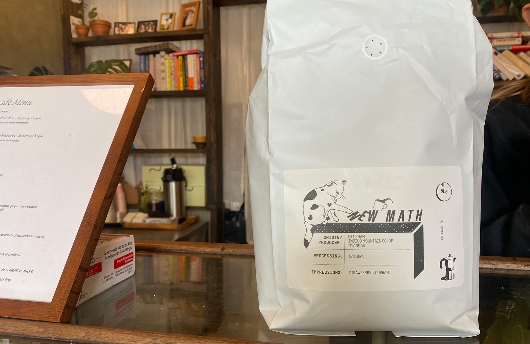 A bag of coffee sits on a bakery counter