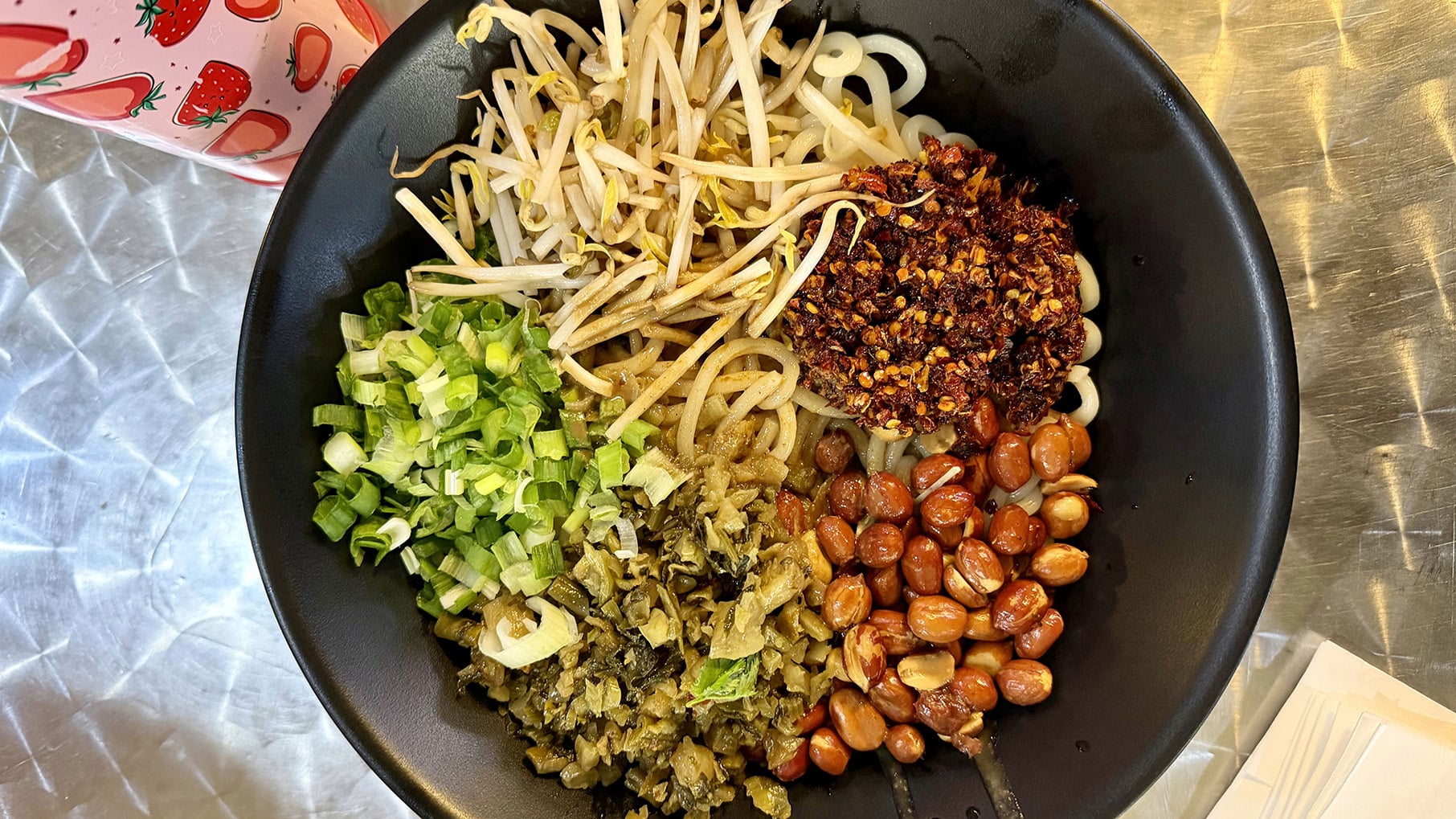 A bowl of noodles with quadrants of toppings