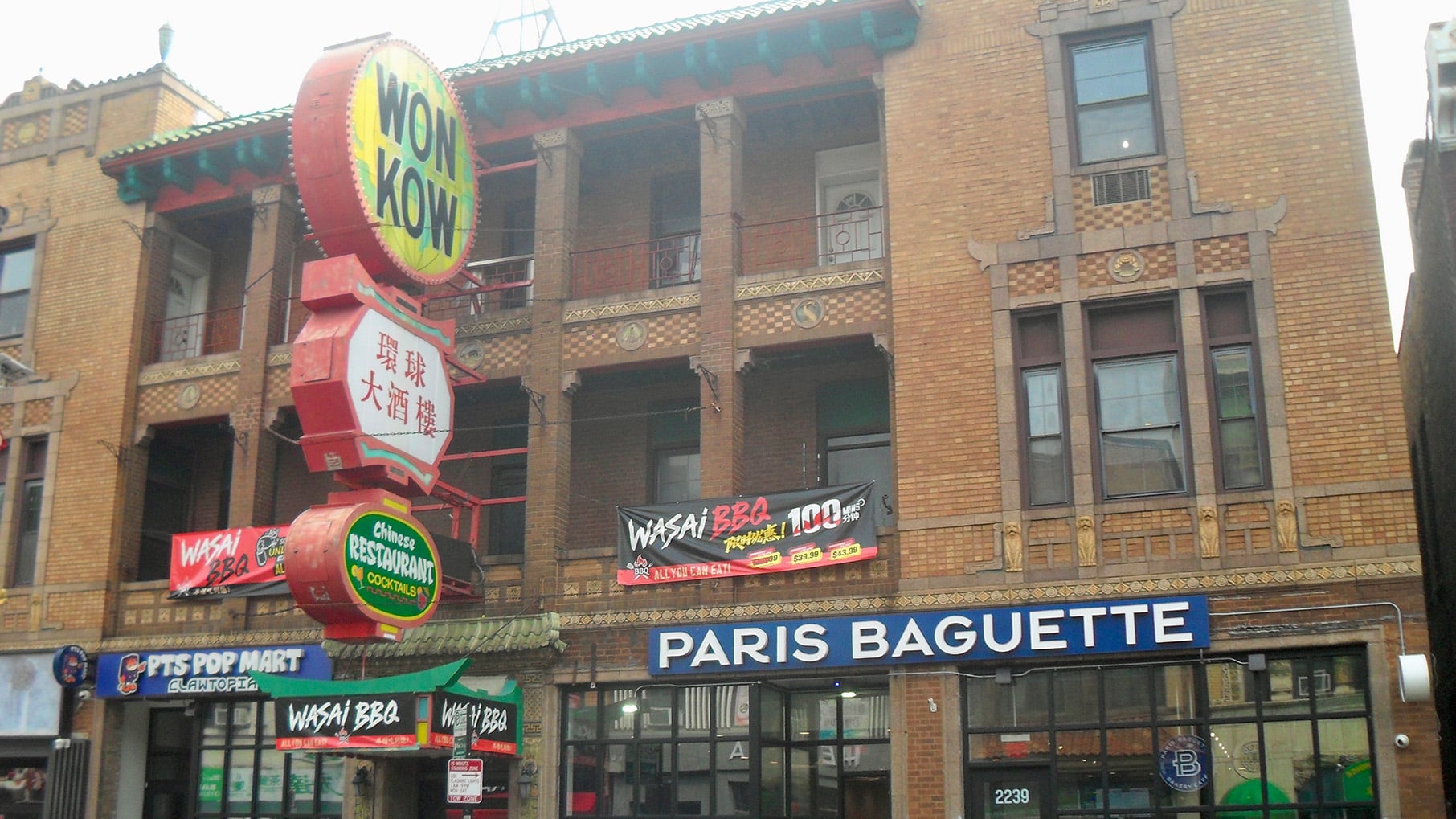 A building in Chicago's Chinatown with a sign for Won Kow and Paris Baguette