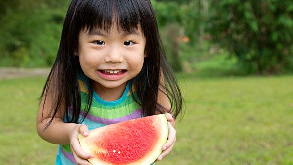 Little girl eating watermelon.