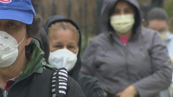 People wearing masks lined up for a food drive in Brighton Park in April 2020. (WTTW News) People wearing masks lined up for a food drive in Brighton Park in April 2020. (WTTW News)