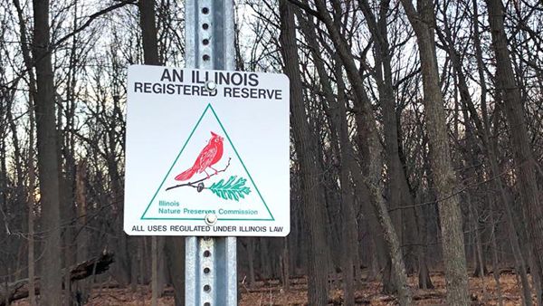 (WTTW News) A sign with a cardinal bird on it reading "An Illinois Registered Reserve."