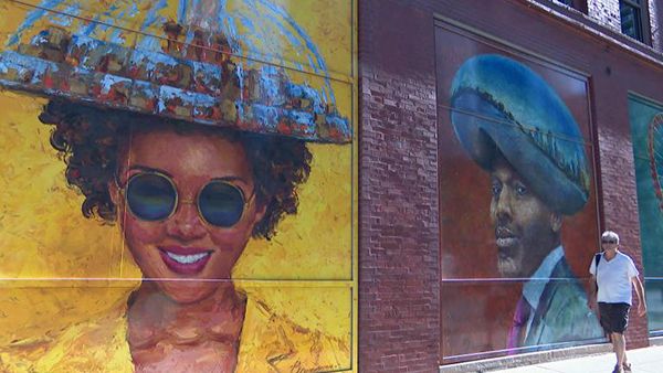 (WTTW News) "Chicago Looks Good On You" murals by Paul Brourman, including one depicting a man wearing "The Bean" on his head. (WTTW News)