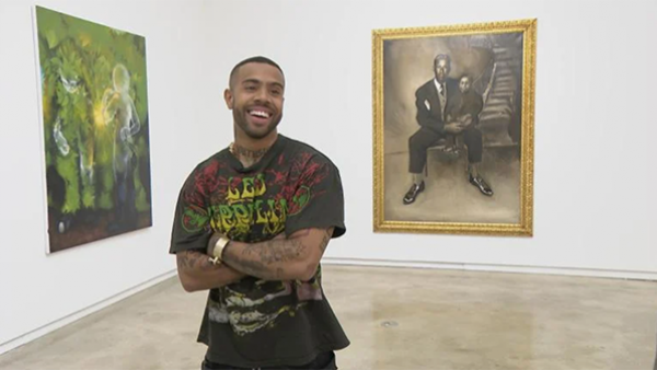 Chicago rapper Vic Mensa (WTTW News) Chicago rapper Vic Mensa standing before two paintings.