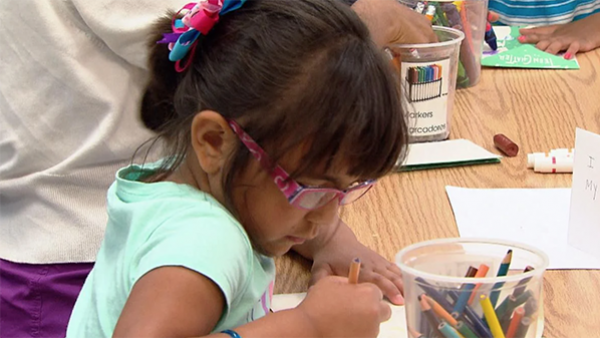 A girl drawing with colored pencils (WTTW News)