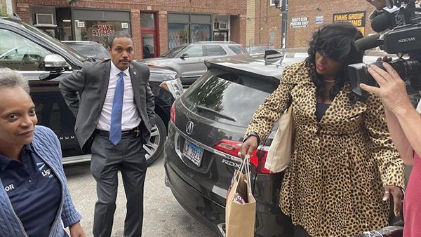 Mayor Lori Lightfoot hits the campaign trail on June 7, 2022, as her security detail looks on. (Heather Cherone/WTTW News)