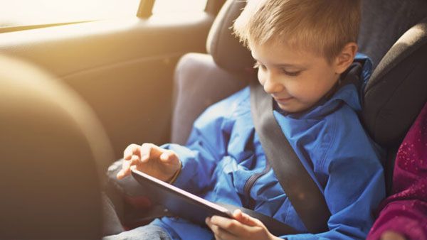Boy playing a game in the car.