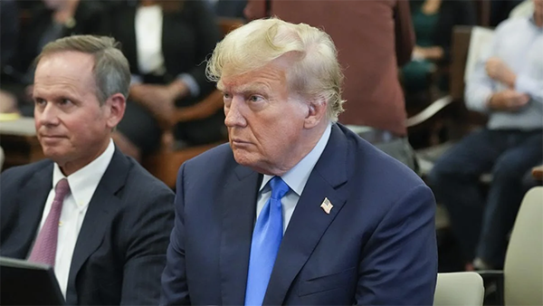 Former President Donald Trump, right, sits in a courtroom at the New York Supreme Court on Monday, October 2, 2023.