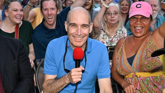 Tour guide WTTW's Geoffrey Baer with microphone amongst group on on boat tour
