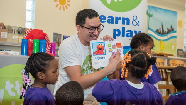 WTTW Kids Learn & Play host Cristian instructs a small group of young children seated before him