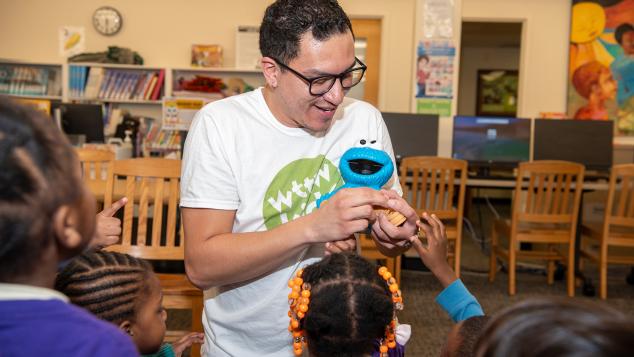 WTTW Kids Learn & Play host Cristian instructs a small group of young children seated before him