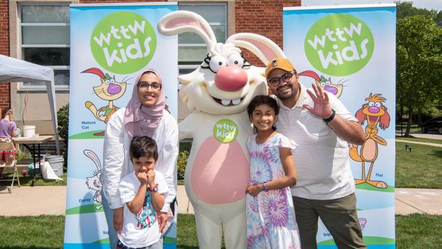 Family of four poses with WTTW Kids' Nature Cat character