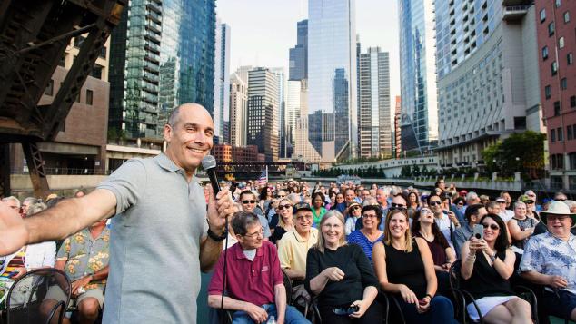 Geoffrey Baer on tour boat full of WTTW Members with the city of Chicago in the background