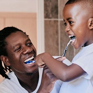 Dad and son brushing teeth.