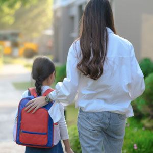 Mom walking child to school.