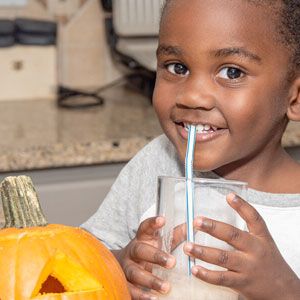 Child drinking pumpkin smoothie.