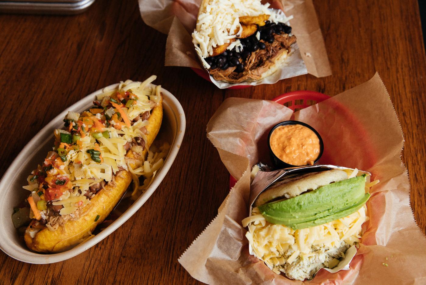 A stuffed plantain, pabellón arepa, and avocado chicken arepa with red pepper sauce at Sweet Pepper Venezuelan Food Bar. Photo: Sandy Noto for WTTW
