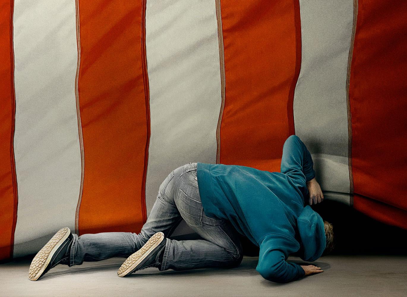Man looking under American flag, ostensibly for the American Dream.