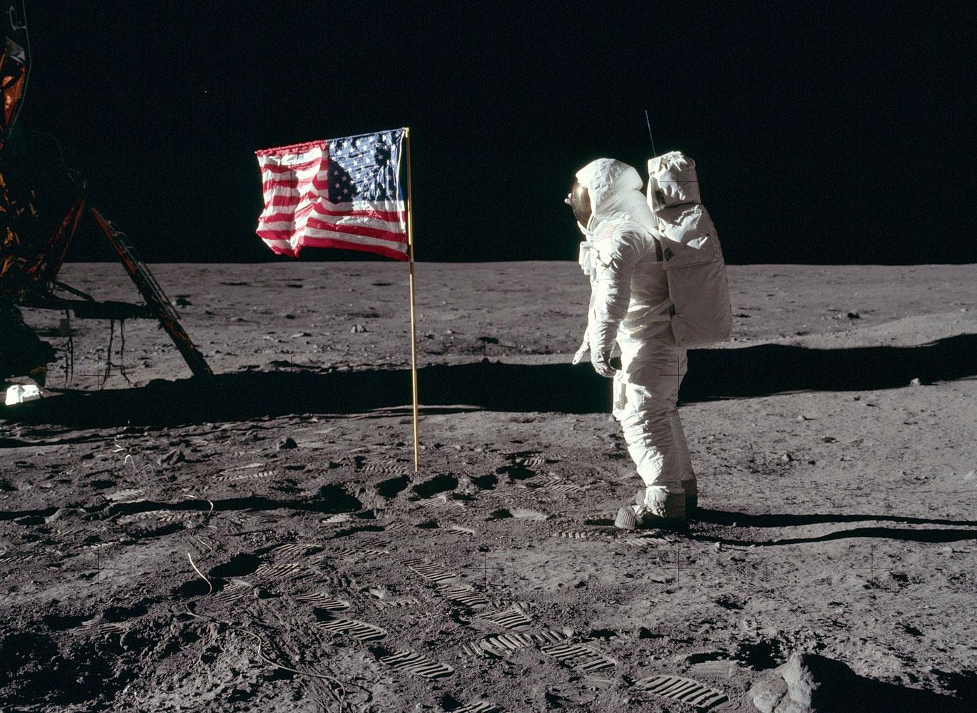 Astronaut Buzz Aldrin, Lunar Module pilot of the first lunar landing mission, poses for a photograph beside the deployed United States flag during an Apollo 11 Extravehicular Activity (EVA) on the lunar surface.