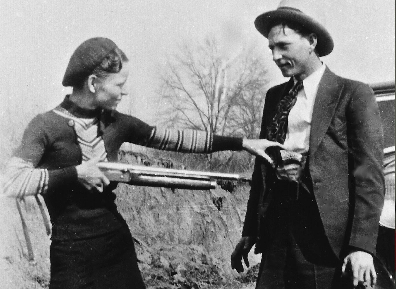 Bonnie Parker and Clyde Barrow, the most famous outlaw couple in U.S. history, posing together in front of car, 1933.