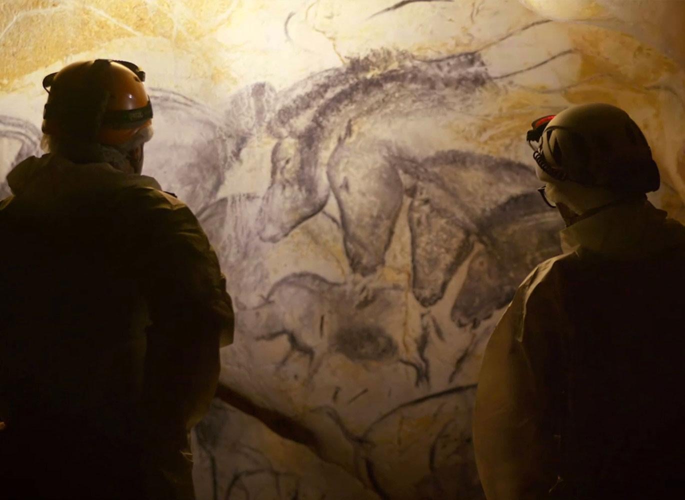 Two scientists staring at the Panel of the Horses