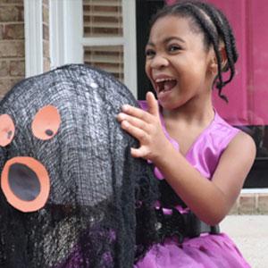 Little girl with Halloween craft.