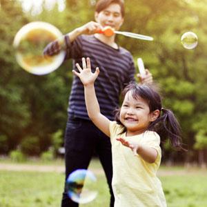 Parent and child blowing bubbles