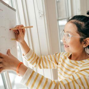Child marking a calendar.