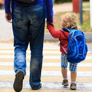 Preschooler holding hands with a parent