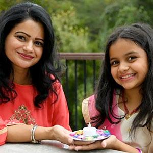 Mom and child presenting their Diwali candle.