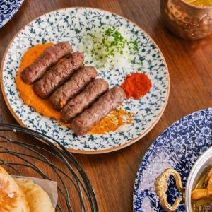 Sausages on a plate amongst other plates on a table