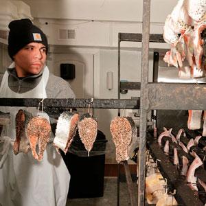 Worker Giovanni Rosas prepares racks of fish to go in the smokehouse, which is located just outside the building.