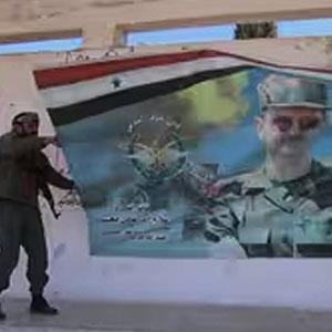 Soldiers remove poster of Assad.