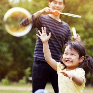 Little girl playing with bubbles