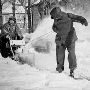 One man pushes a snowblower while two men pull with rope to clean the sidewalk after the blizzard of 1967 in Chicago. Credit: Chicago History Museum, MDN-0000013; Chicago Daily News, photographer