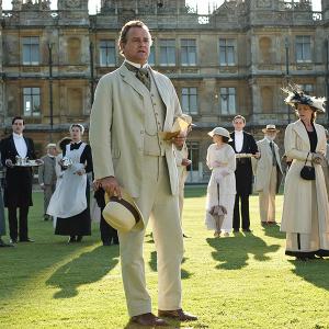 The cast of Downton Abbey stands outside during a garden party